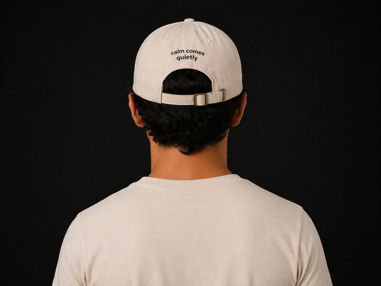 Handsome male model wearing Quiet Tide signature cap in natural color, Back view with minimalist logo, premium neutral aesthetic