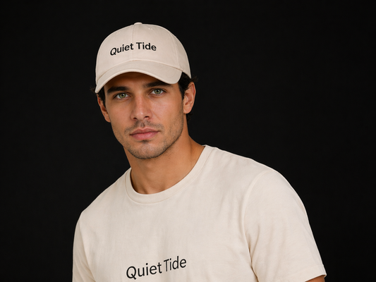 Handsome male model wearing Quiet Tide signature cap in natural color, front view with minimalist logo, premium neutral aesthetic