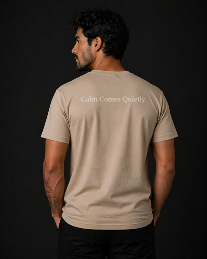 man wearing quiet tide tan calm statement tee back calm comes quietly text